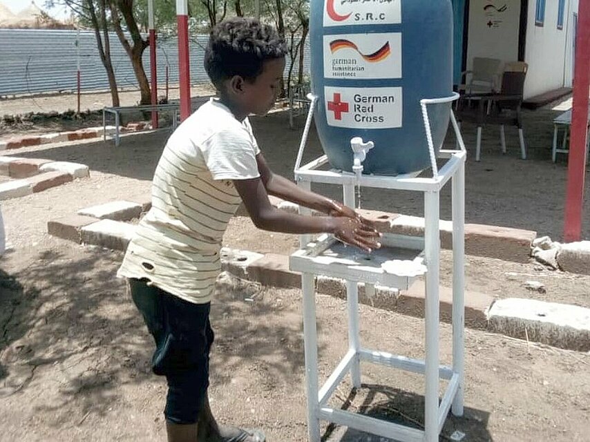 Junge aus dem Sudan an Handwasch-Station