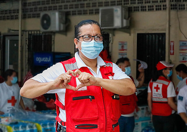 Rotkreuz-Helferin macht mit ihren Händen ein Herz