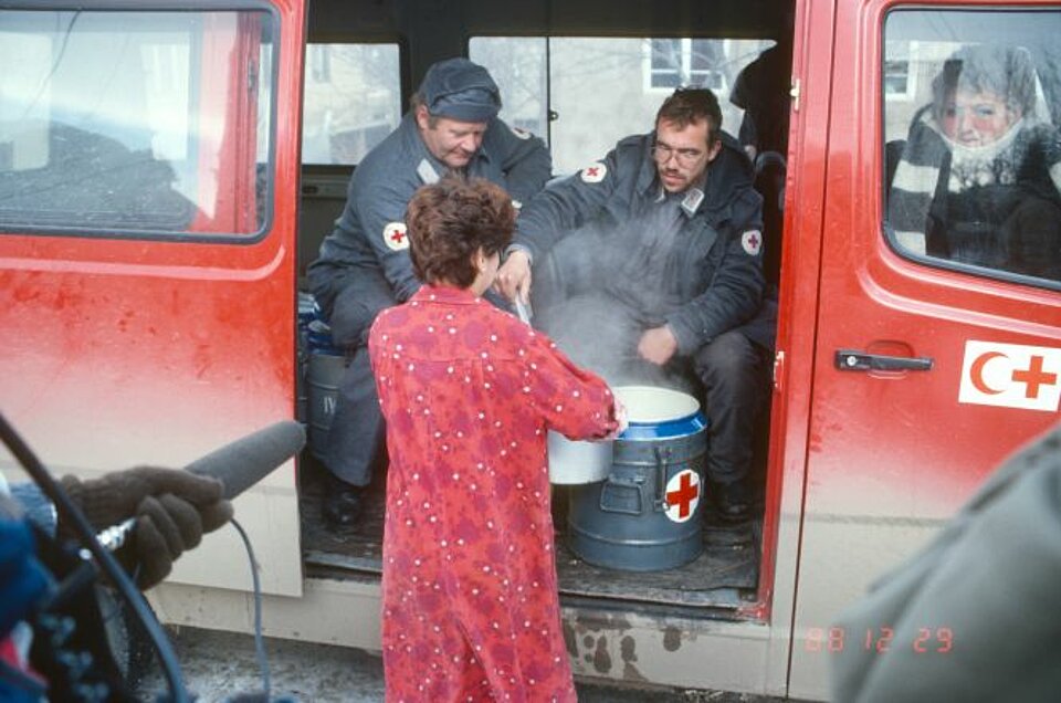 Armenien, Auto, Bevölkerung, Deutsches Rotes Kreuz, Essen, Fahrzeug, Frau, Hilfe, Kaukasus, Kessel, Küche, Mikrofon, Reporter, Sowjetunion, Suppe, Thermophore, Zusammenarbeit, mobile