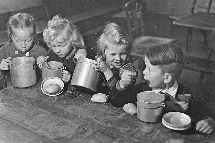 Kinder essen aus Alutöpfchen