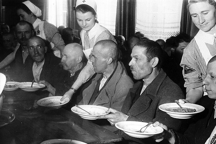 Männer bei Tisch mit Suppentellern