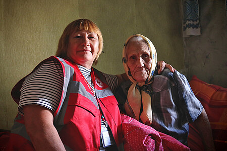 Rotkreuz-Pflegerin mit Seniorin in der Ukraine