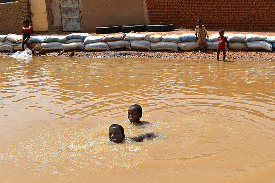Sudanesische Kinder schwimmen im Hochwasser