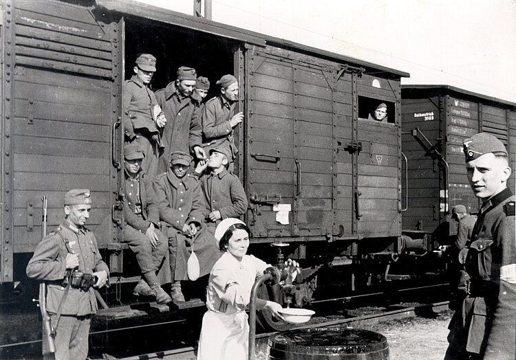Mit dem Zug nach Leipzig transportierte polnische Kriegsgefangene erhalten Verpflegung durch das DRK