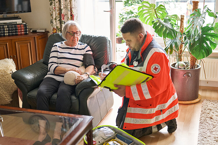 DRKler und Seniorin mit angelegtem Blutdruckmessgerät