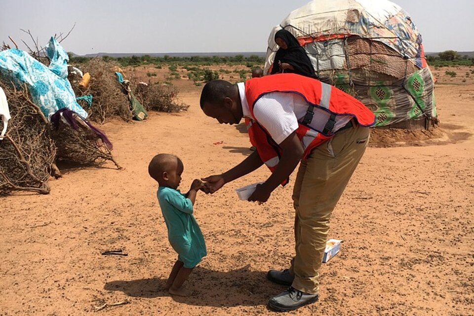 Somalischer Rotkreuzhelfer mit Kind