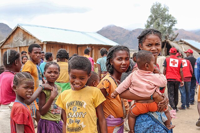 Kinder mit Rotkreuz-Helfern in Madagaskar