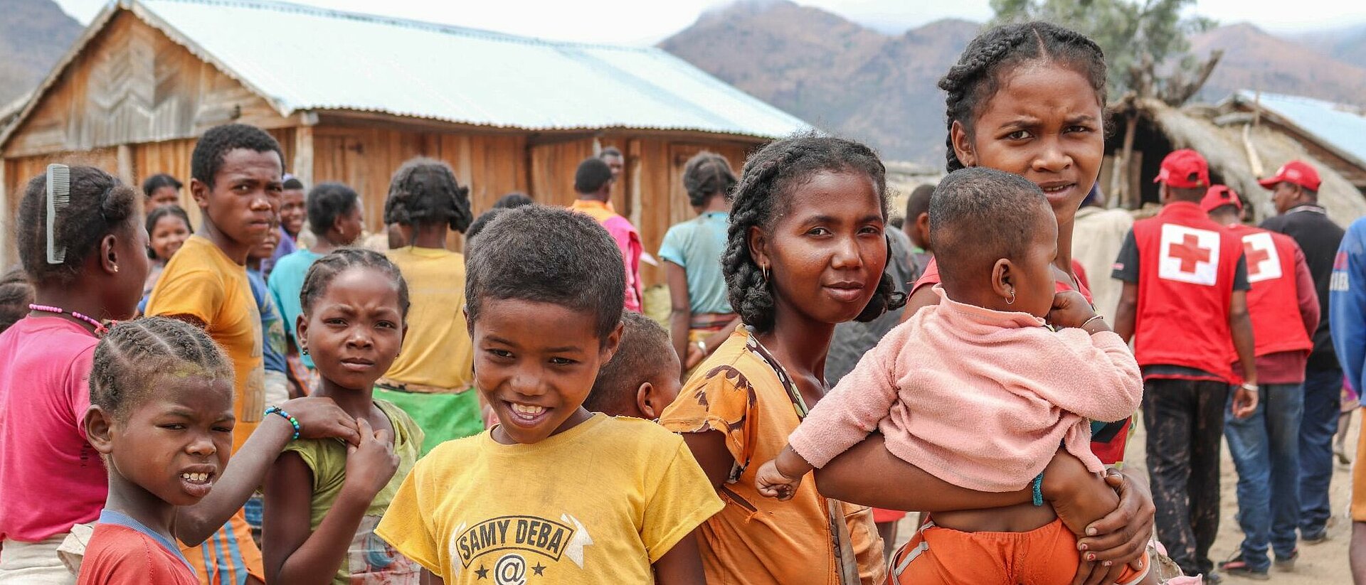 Kinder mit Rotkreuz-Helfern in Madagaskar