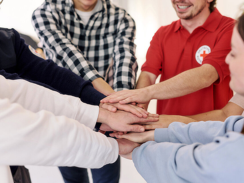 Corporate Volunteering: Mitarbeitende legen Hände übereinander