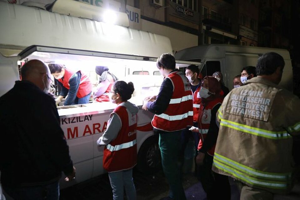 Helferinnen und Helfer des Türkischen Roten Halbmonds versorgen die Einsatzkräfte vor Ort mit einer warmen Mahlzeit und Getränken.