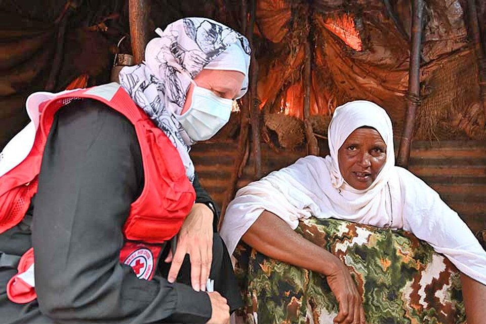 Rotkreuzlerin spricht mit somalischer Frau