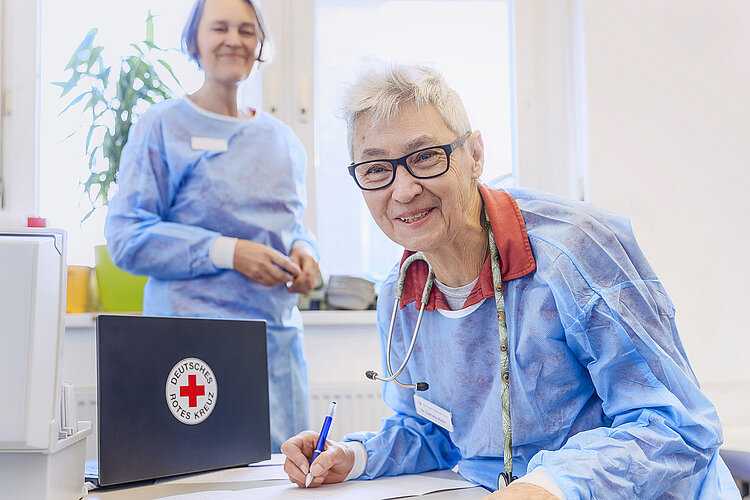lächelnde Ärztin am Schreibtisch 