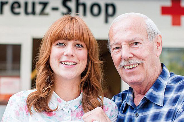 Foto: Eine junge Frau und ein älterer Mann vor einem Rotkreuz-Shop