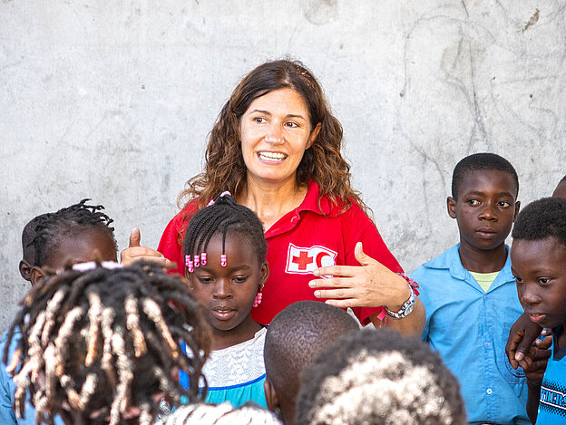 IFRC-Mitarbeiterin umringt von Kindern