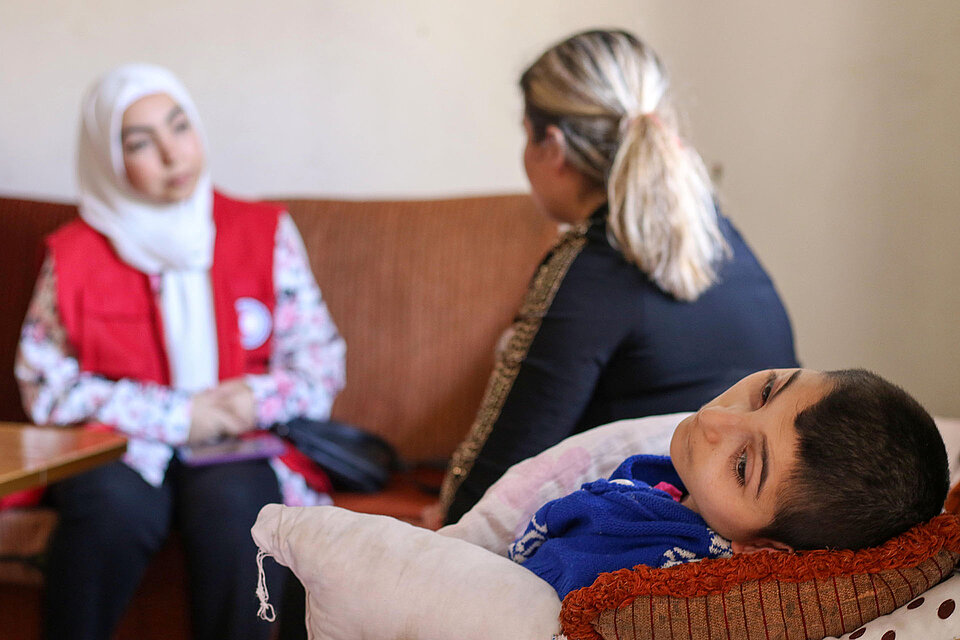 Rothalbmond-Freiwillige im Gespräch mit Syrerin