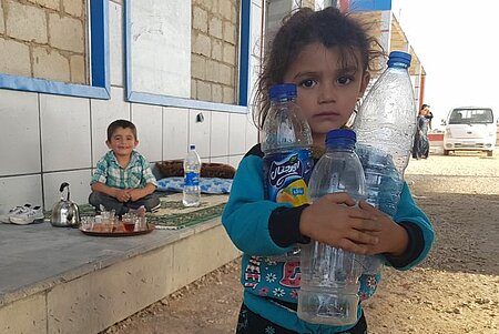 Kind mit leeren Wasserflaschen in Nordsyrien