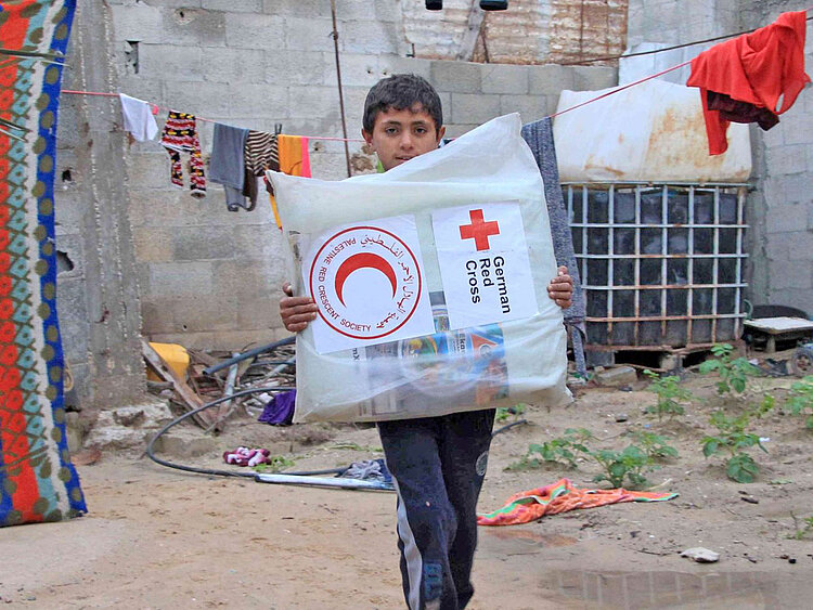 Junge mit Rotkreuz-Hilfspaket in Palästina, Gaza