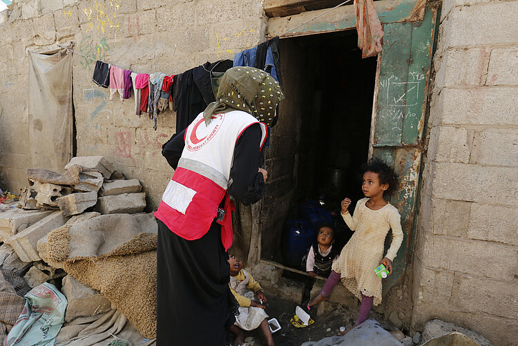 Spenden für arme Menschen: Helferin spricht mit Kind im Jemen