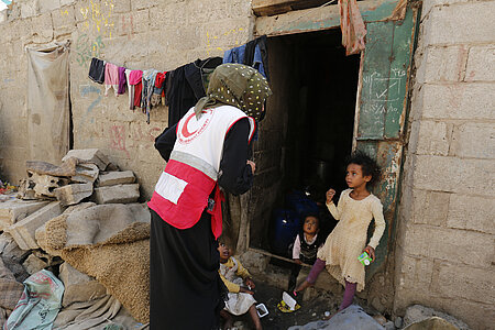 Spenden für arme Menschen: Helferin spricht mit Kind im Jemen