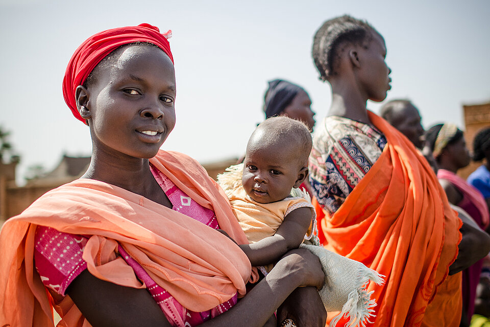 Eine Sudanesin mit Baby im Arm