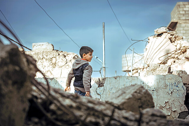 Syrischer Junge zwischen Trümmern