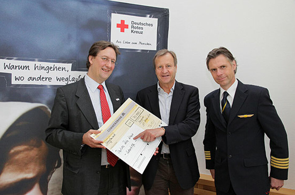 Foto: TUIfly-Geschärtsführer Friedrich Keppler und Pilot Jörg Schönfeld überreichen einen symblischen Scheck an DRK-Generalsekretär Graf Waldburg-Zeil.