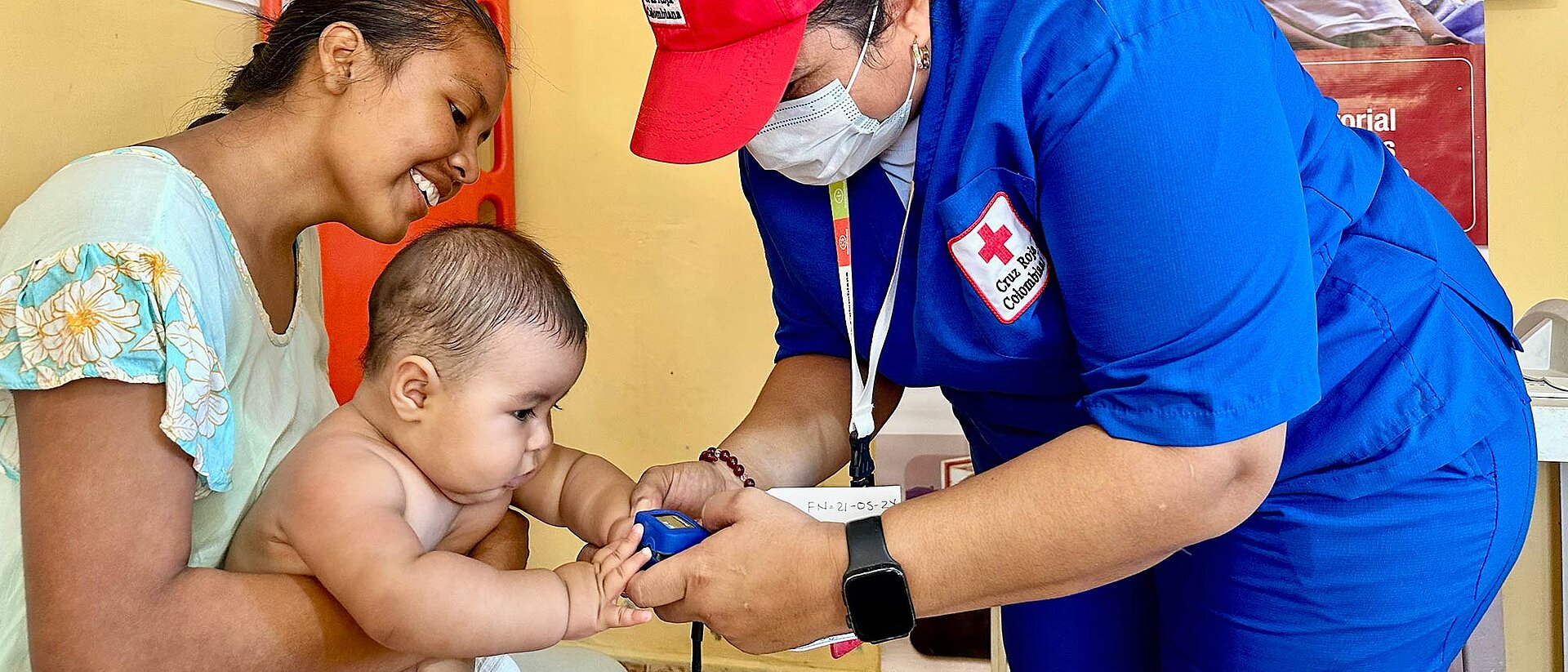 Rotkreuzlerin untersucht Baby auf Schoß der Mutter