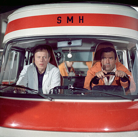 'Bereitschaft Dr. Federau', Folge 'Rückfall', 1988: mit Peter Cwielag als Fahrer Bert Holländer (li) und Günter Schubert als SMH-Fahrer Axel Dünnebier (Stiftung Deutsches Rundfunkarchiv / Oliver Klar)