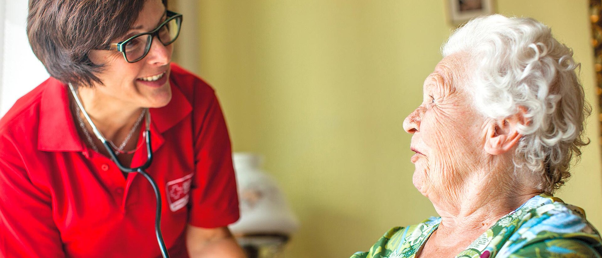 DRK-Fachkraft misst Blutdruck bei Seniorin