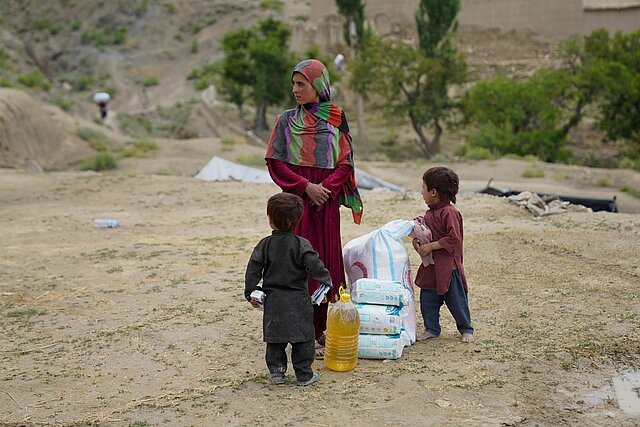 Woman with two children and relief supplies in Afghanistan