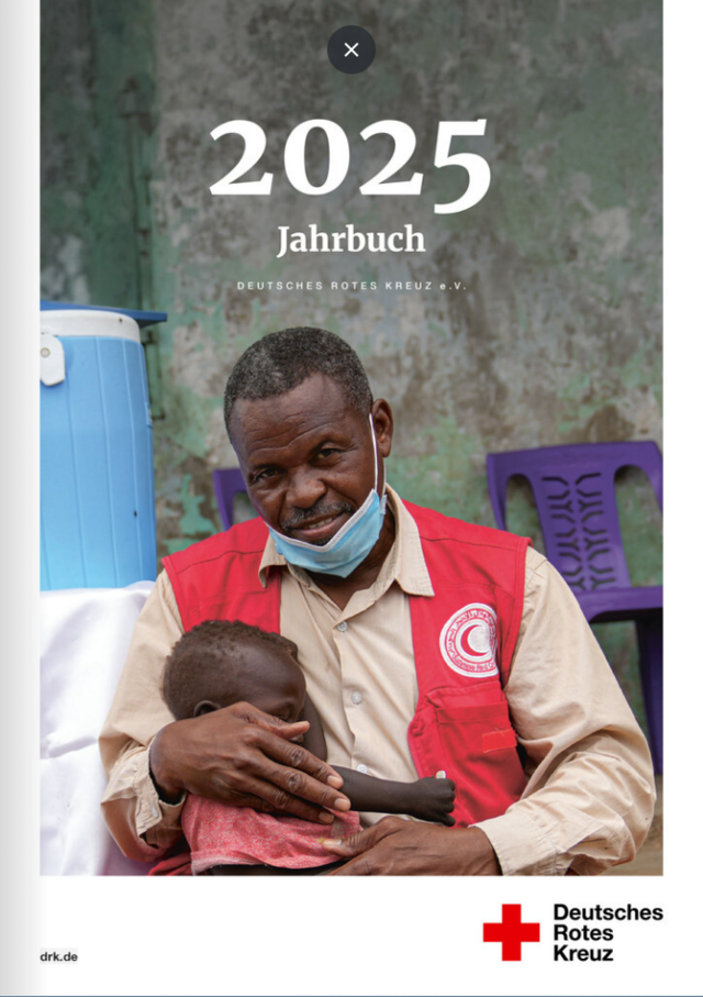 Mann mit Kind auf dem Arm - Cover des DRK Jahrbuchs 2025
