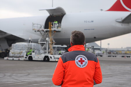 Hilfsflug des DRK vom Flughafen Leipzig mit einem DRK-Angestellten im Vordergrund