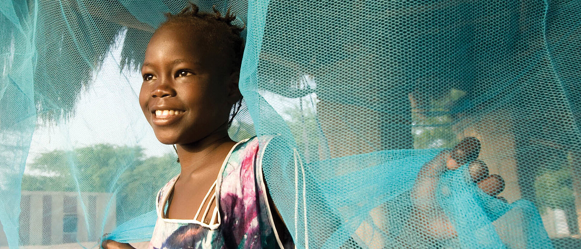 Mädchen mit Moskitonetz im Senegal 