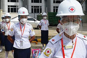 Freiwillige des Myanmarischen Roten Kreuzes in Uniform und Infektionsschutzausrüstung