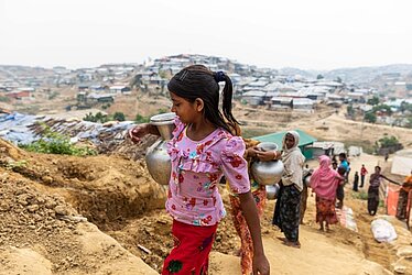 Geflüchtetes Mädchen in der Region Cox's Bazar in Bangladesch trägt einen Krug