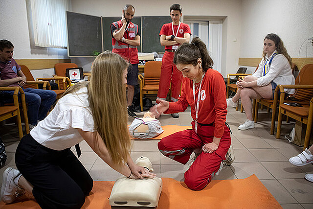 Rotkreuzlerin und junge Frau bei Erste-Hilfe-Übung