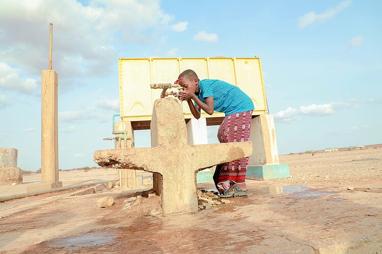 Wasserverrsorgung in Afrika Junge an Brunnen in Somalia