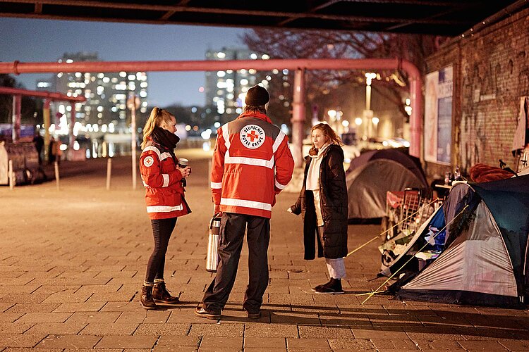 Ehrenamtliche sprechen mit einer Oblachlosen