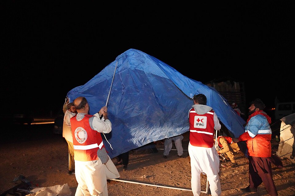 Helfende bauen ein Zelt nach dem Erdbeben in Afghanistan auf