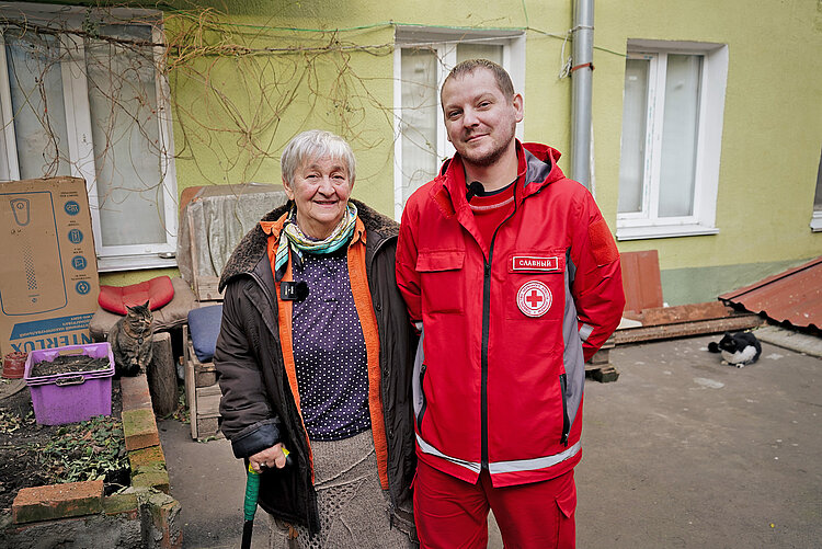 Ältere Frau und Rotkreuzmitarbeiter in der Ukraine 