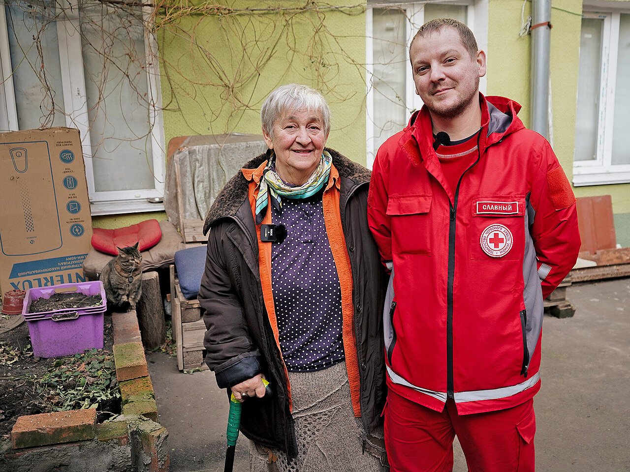 Ältere Frau und Rotkreuzmitarbeiter in der Ukraine 