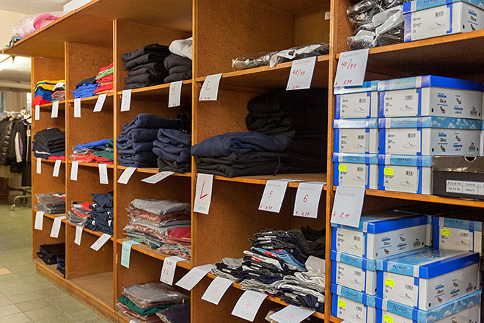 Regale mit Kleidung und Schuhen im Lager Friedland
