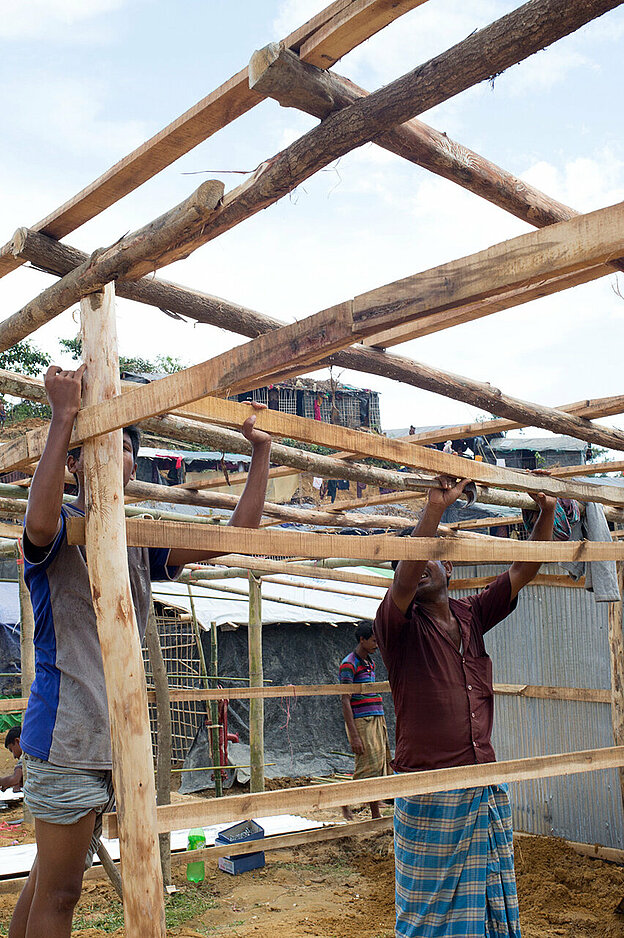 Bangladeschische Männer bauen eine Holzkonstruktion