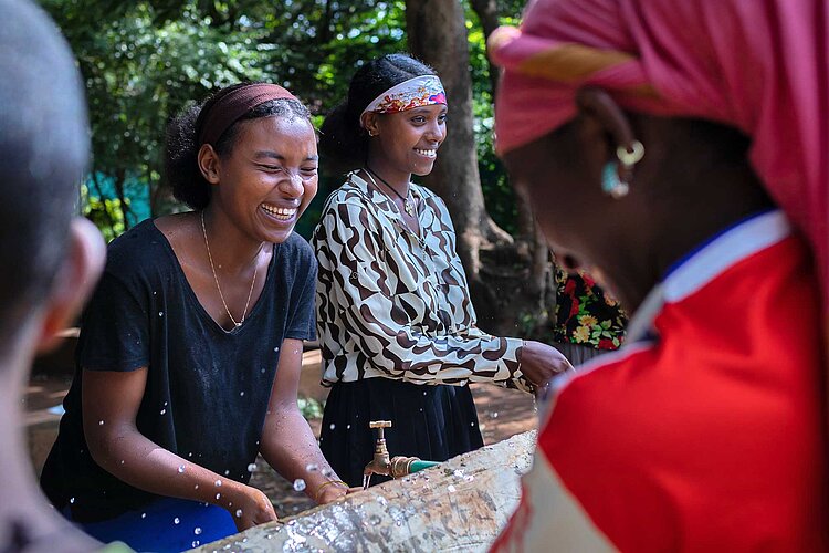 Jugendliche waschen sich Gesichter und lachen