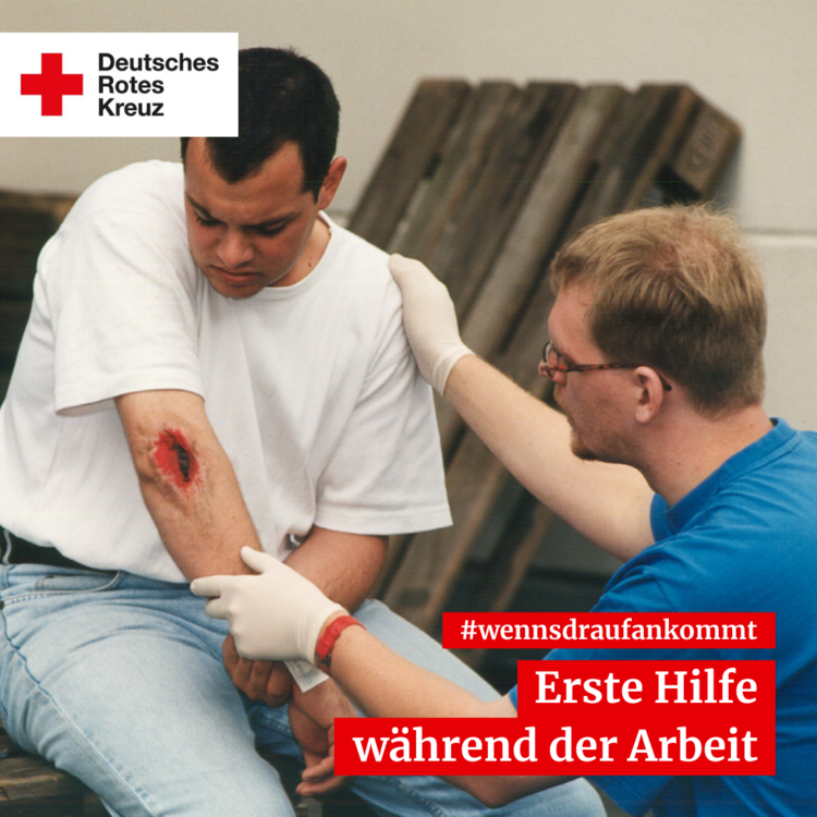 Erste Hilfe leistende Person bei einer Verletzung am Arm