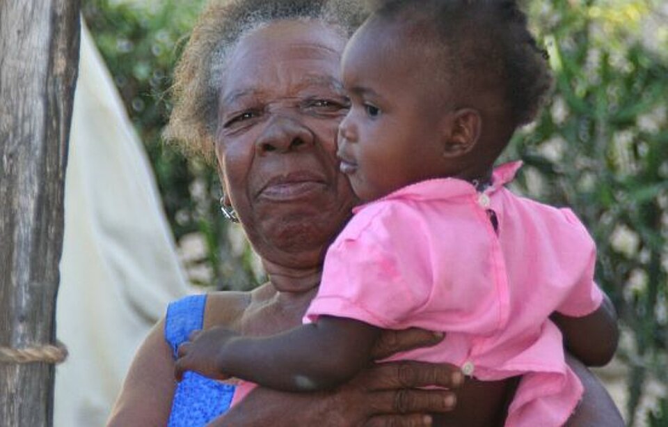 Foto: Eine alte haitianische Frau mit einem kleinen Mädchen auf dem Arm