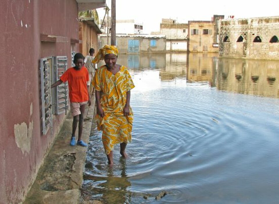 Eine Mutter und ihr Kind in den Überschwemmungsgebieten in Dakar, Senegal