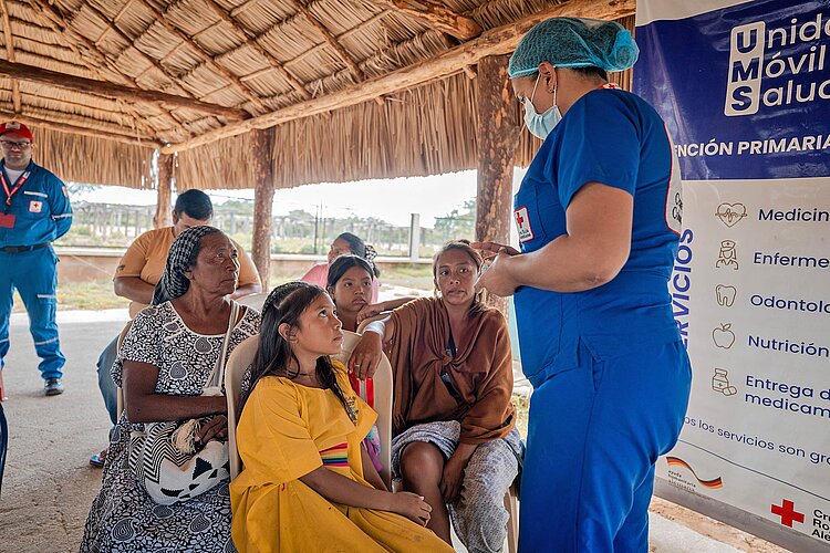 Rotkreuzlerin spricht mit Gruppe von Frauen/Mädchen