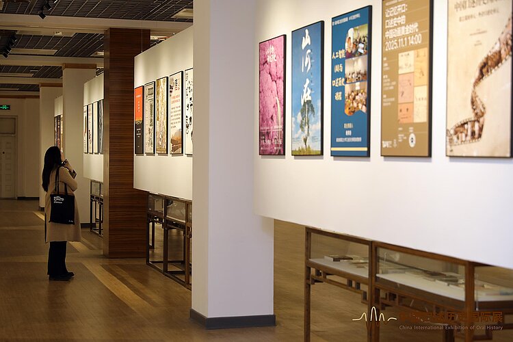 Frau schaut sich Plakate an Wand an