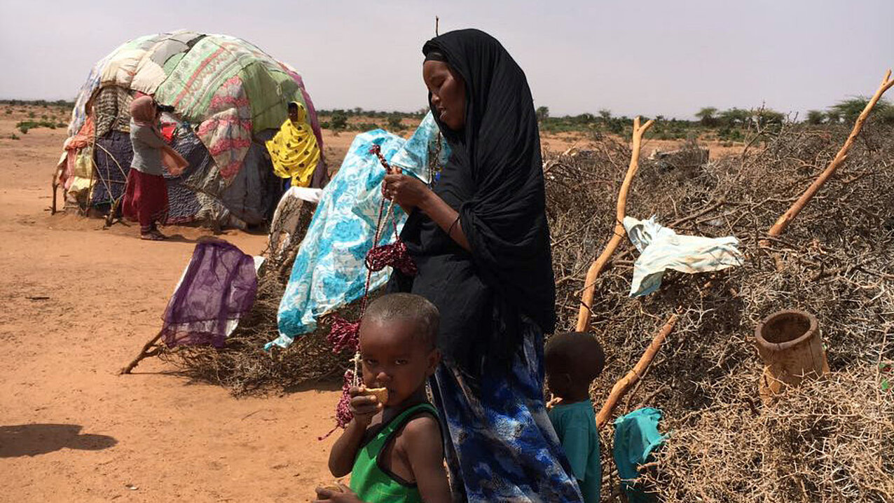 Somalierin und Kind vor Hütte